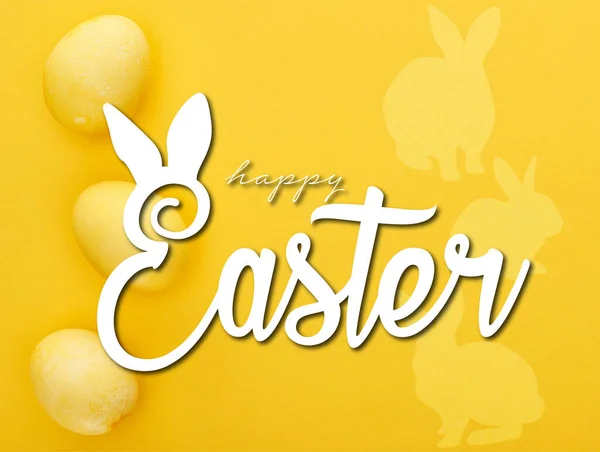 Top view of painted Easter eggs on colorful yellow background with happy Easter illustration — Stock Photo