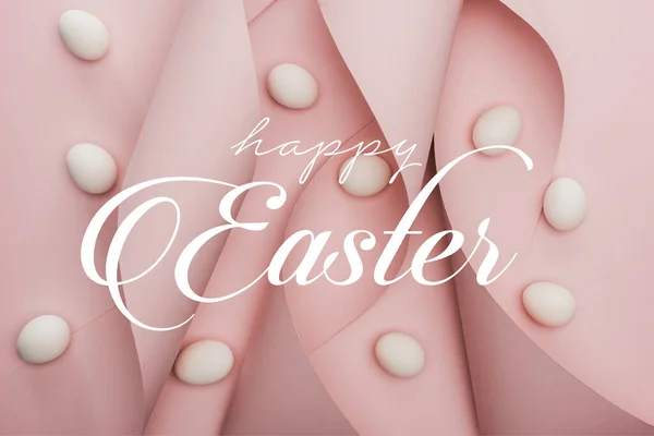 Vista superior de ovos de galinha em espiral de papel rosa redemoinhos com feliz ilustração da Páscoa — Fotografia de Stock