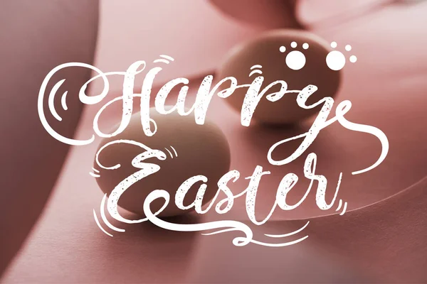 Enfoque selectivo de huevos de gallina en sombra en espiral papel rosado remolinos con feliz ilustración de Pascua - foto de stock