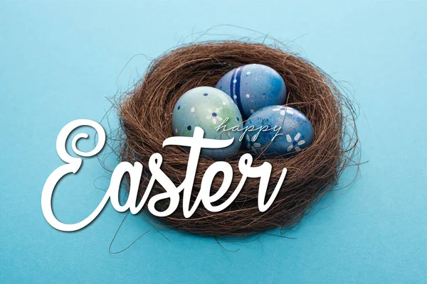 Close up view of Easter eggs in nest on blue with happy Easter illustration — Stock Photo