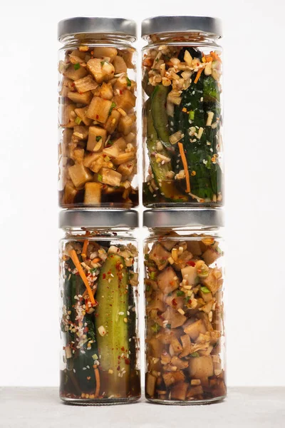 Pepino e daikon rabanete kimchi em frascos de vidro isolados em branco — Fotografia de Stock