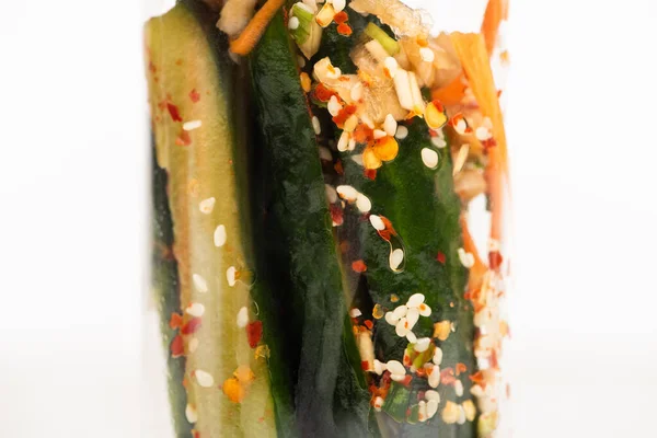 Close up of tasty cucumber kimchi in glass jar isolated on white — Stock Photo