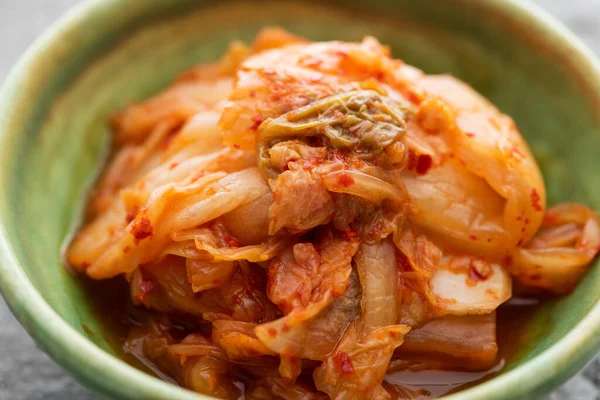 Close up of tasty cabbage kimchi in green bowl — Stock Photo