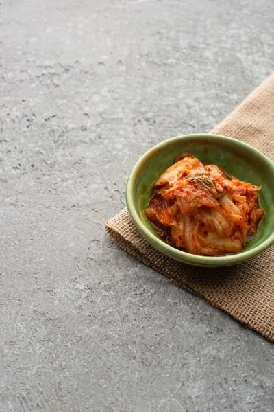 Bol de kimchi coréen savoureux et sac sur la surface du béton — Photo de stock