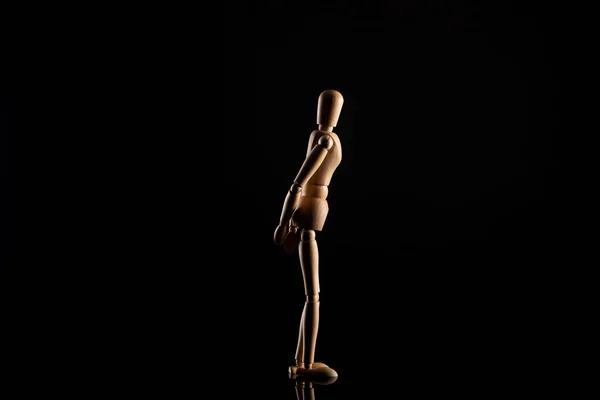 Wooden doll in standing position on black background — Stock Photo