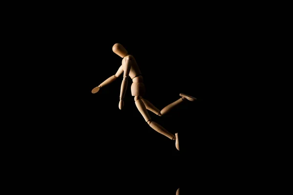 Marionnette en bois en position de chute sur noir — Photo de stock