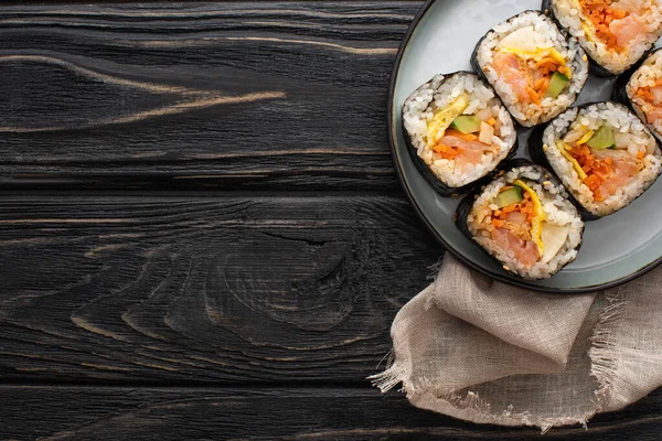 Top view of plate with korean gimbap on wooden surface — Stock Photo