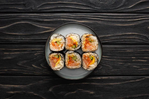 Top view of plate with tasty gimbap on wooden surface — Stock Photo