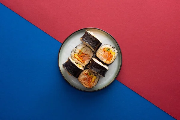 Vista superior de la placa con delicioso gimbap en carmesí y azul - foto de stock