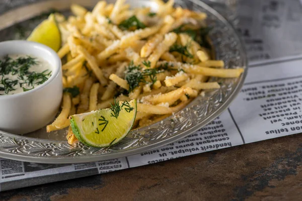 Selektiver Fokus auf Pommes und Limettenscheiben auf dem Teller — Stockfoto