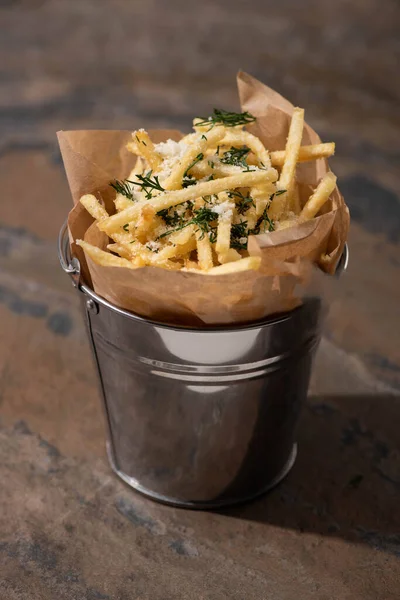 Balde de batatas fritas crocantes na superfície de mármore — Fotografia de Stock