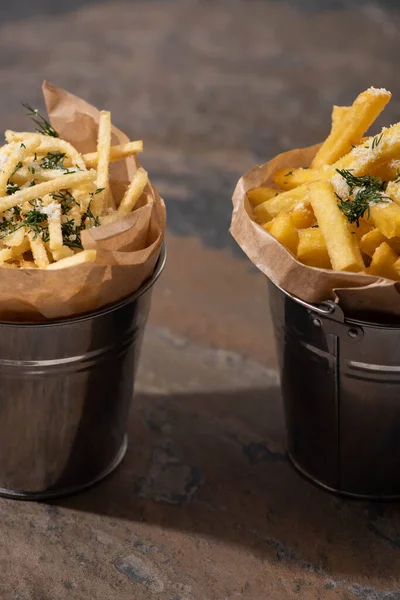 Buckets of crispy french fries on marble surface — Stock Photo