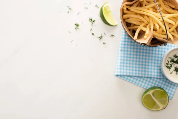 Vista dall'alto di patatine fritte, salsa all'aglio e lime affettato su bianco — Foto stock