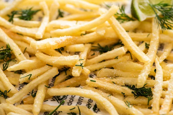 Primo piano di patatine fritte croccanti con aneto sul giornale — Foto stock