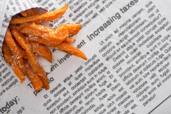 Vista dall'alto di patatine fritte croccanti con sale sul giornale — Foto stock