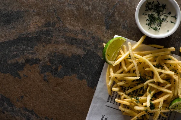 Top view of crispy french fries, lime and garlic sauce on marble surface — Stock Photo