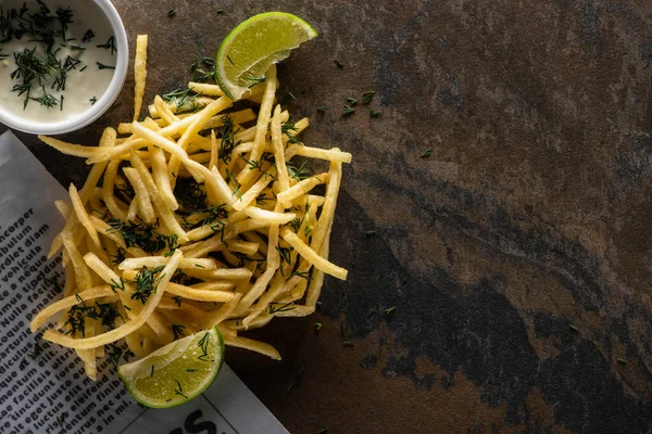 Vista superior de batatas fritas saborosas, limão e molho de alho na superfície de mármore — Fotografia de Stock