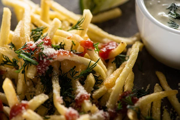 Close up of tasty french fries with ketchup, salt and dill near garlic sauce — Stock Photo