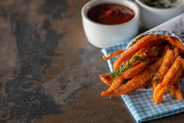 Foyer sélectif de frites avec du sel près du ketchup et de la sauce à l'ail sur la surface du marbre — Photo de stock