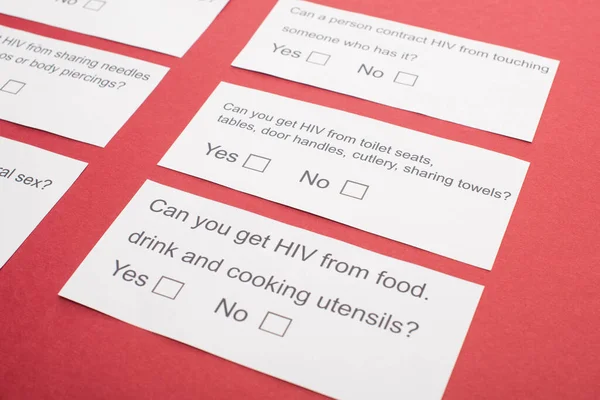 Carte cartacee con questionario HIV su sfondo rosso — Foto stock