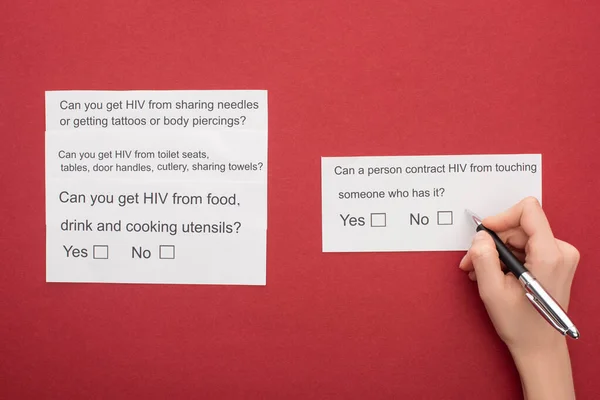 Vista parziale della donna che risponde al questionario HIV su sfondo rosso — Foto stock