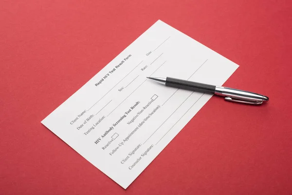 Rapid HIV test result form with pen on red background — Stock Photo