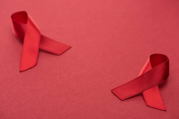 Red awareness aids ribbons on red background — Stock Photo