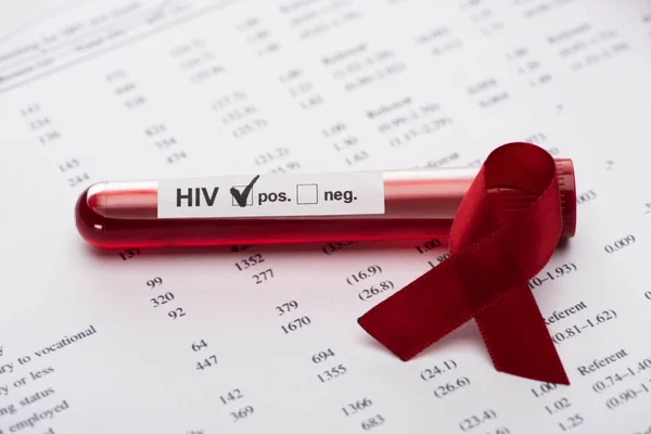 Positive hiv blood sample test on paper result form with awareness ribbon — Stock Photo