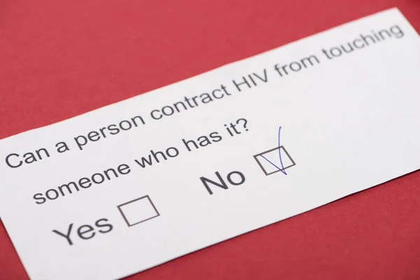 Paper card with HIV questionnaire on red background — Stock Photo