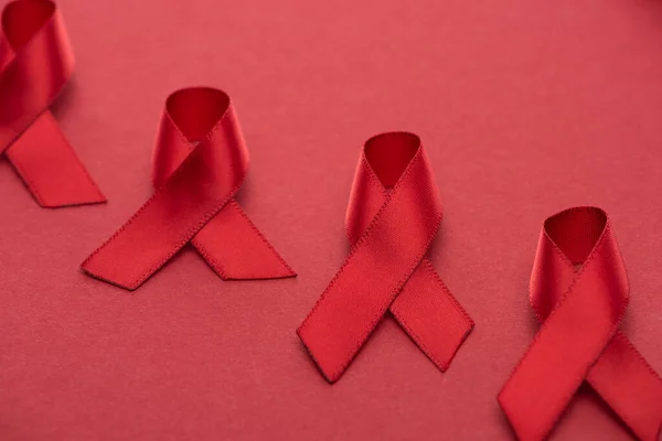 Red awareness aids ribbons on red background — Stock Photo