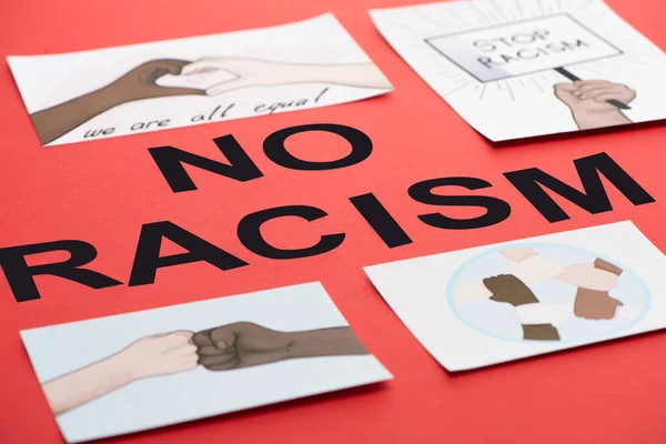 Черные нет расизма надписи среди фотографий с многонациональными руками на красном фоне — стоковое фото