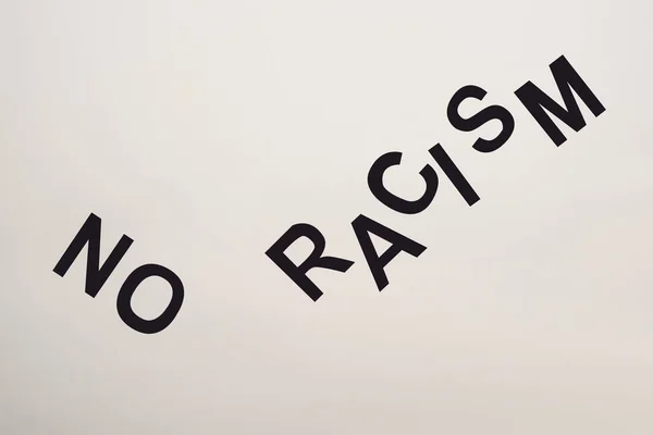 Top view of black no racism lettering isolated on white — Stock Photo