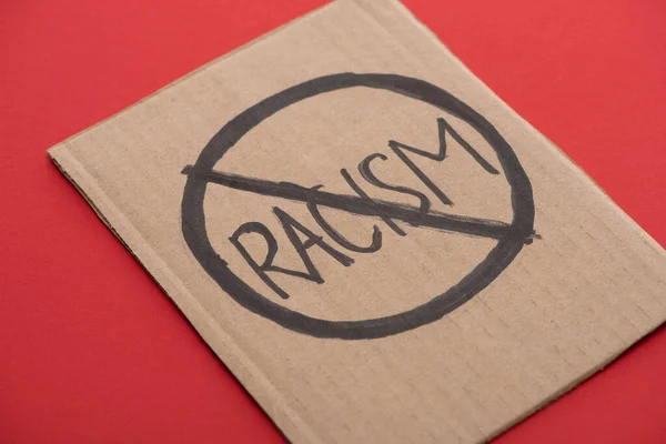 Plaque en carton avec panneau anti-racisme sur fond rouge — Photo de stock