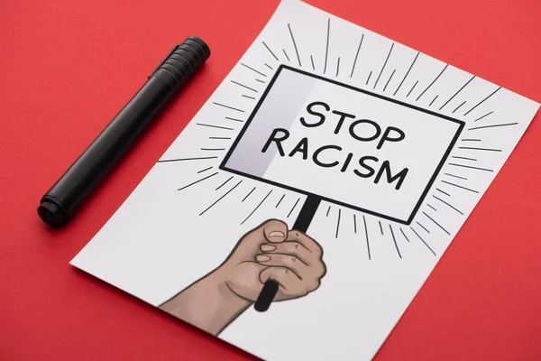 Black marker and picture with drawn hand and stop racism placard on red background — Stock Photo