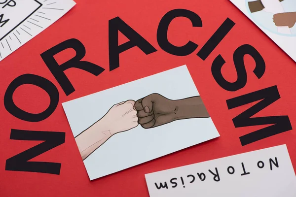 Black no racism lettering and picture with drawn multiethnic hands doing fist bump on red background — Stock Photo