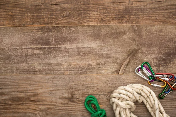 Top view of hiking ropes and carabiners on wooden table — Stock Photo