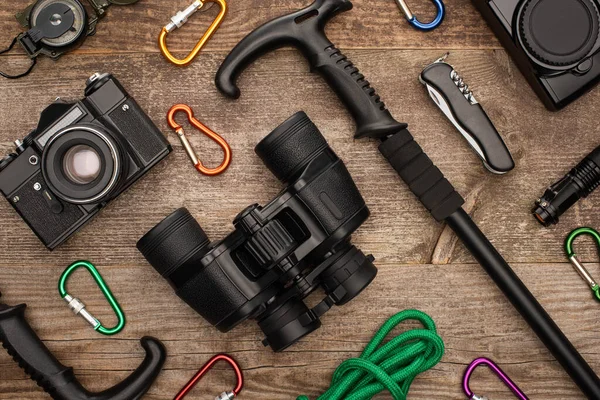 Binoculares y cámaras fotográficas sobre mesa de madera - foto de stock