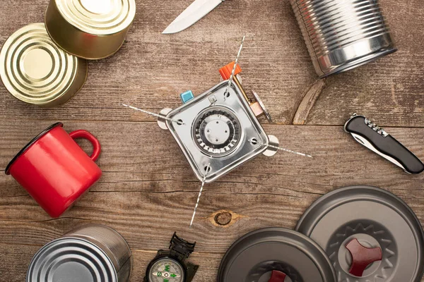 Vista superior do queimador de gás, latas de estanho, copo de metal, na mesa de madeira — Fotografia de Stock