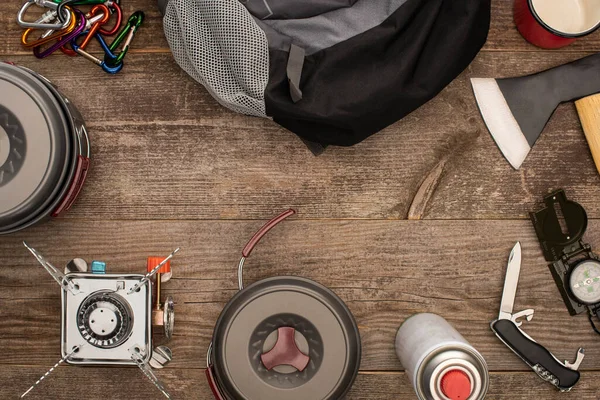 Top view of hiking equipment near backpack on wooden surface — Stock Photo