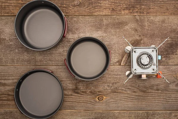 Vue de dessus des plats de camping et brûleur à gaz sur table en bois — Photo de stock