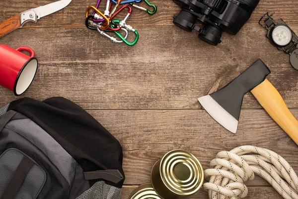 Vista superior de la mochila y equipo de senderismo en mesa de madera - foto de stock