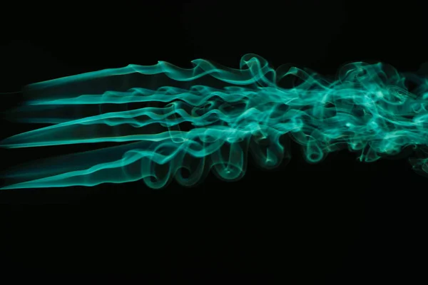 Green colorful flowing smoke on black background — Stock Photo