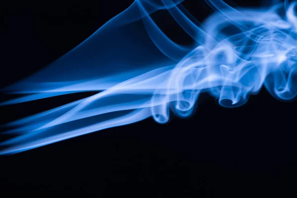 Humo que fluye colorido azul sobre fondo negro - foto de stock