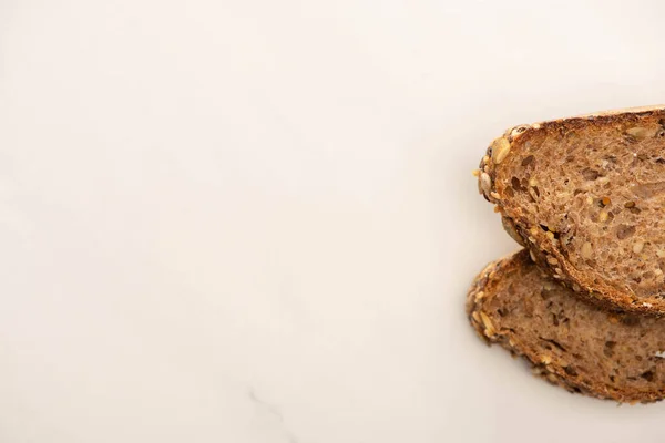 Draufsicht auf frische braune Brotscheiben auf weißem Hintergrund — Stockfoto