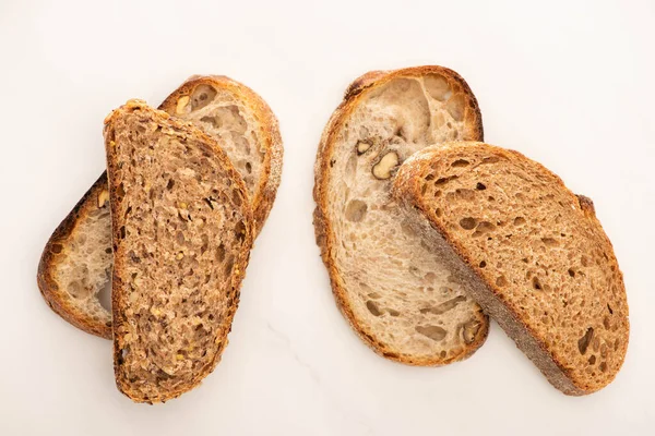 Draufsicht auf frische Vollkornbrotscheiben auf weißem Hintergrund — Stockfoto