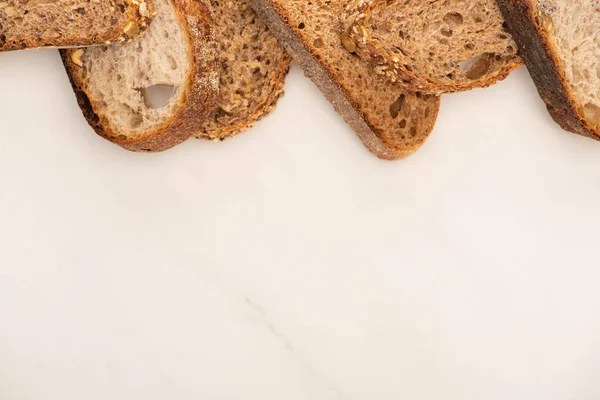 Draufsicht auf frische Vollkornbrotscheiben auf weißem Hintergrund mit Kopierfläche — Stockfoto