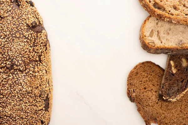 Vista dall'alto di fresche fette di pane integrale e pagnotta su sfondo bianco con spazio copia — Foto stock