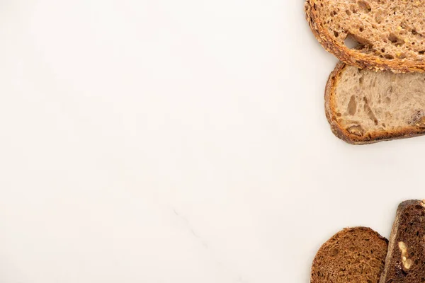 Draufsicht auf frische Vollkornbrotscheiben auf weißem Hintergrund mit Kopierfläche — Stockfoto