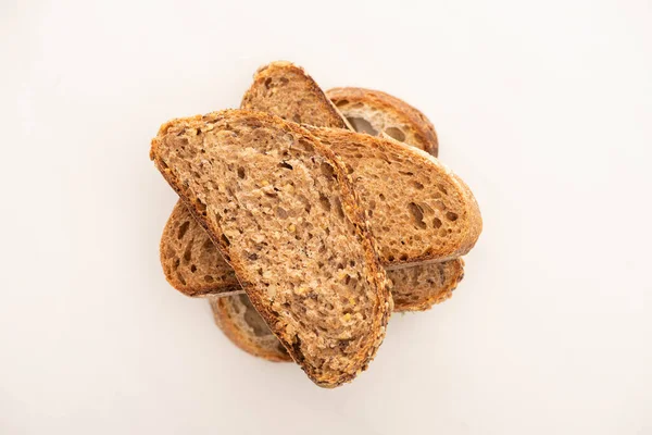 Vue de dessus des tranches de pain de grains entiers frais en pile sur fond blanc — Photo de stock