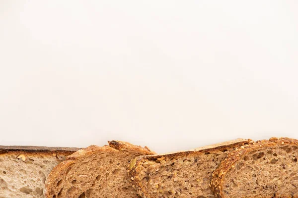 Vue de dessus des tranches de pain de grains entiers frais sur fond blanc avec espace de copie — Photo de stock